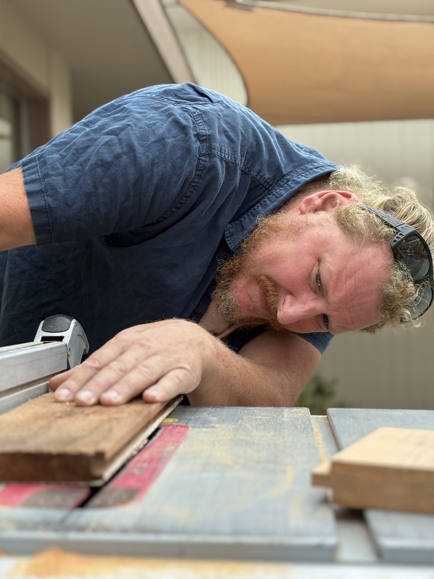 Chris, owner of Handcrafted Enterprises, checking a board at the table saw